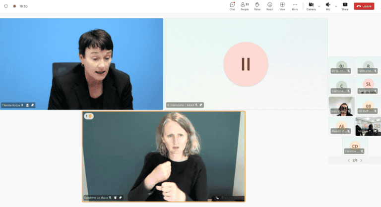 A woman speaks during a virtual meeting while a sign language interpreter translates in a separate video window. Other participant icons are visible on the right side.